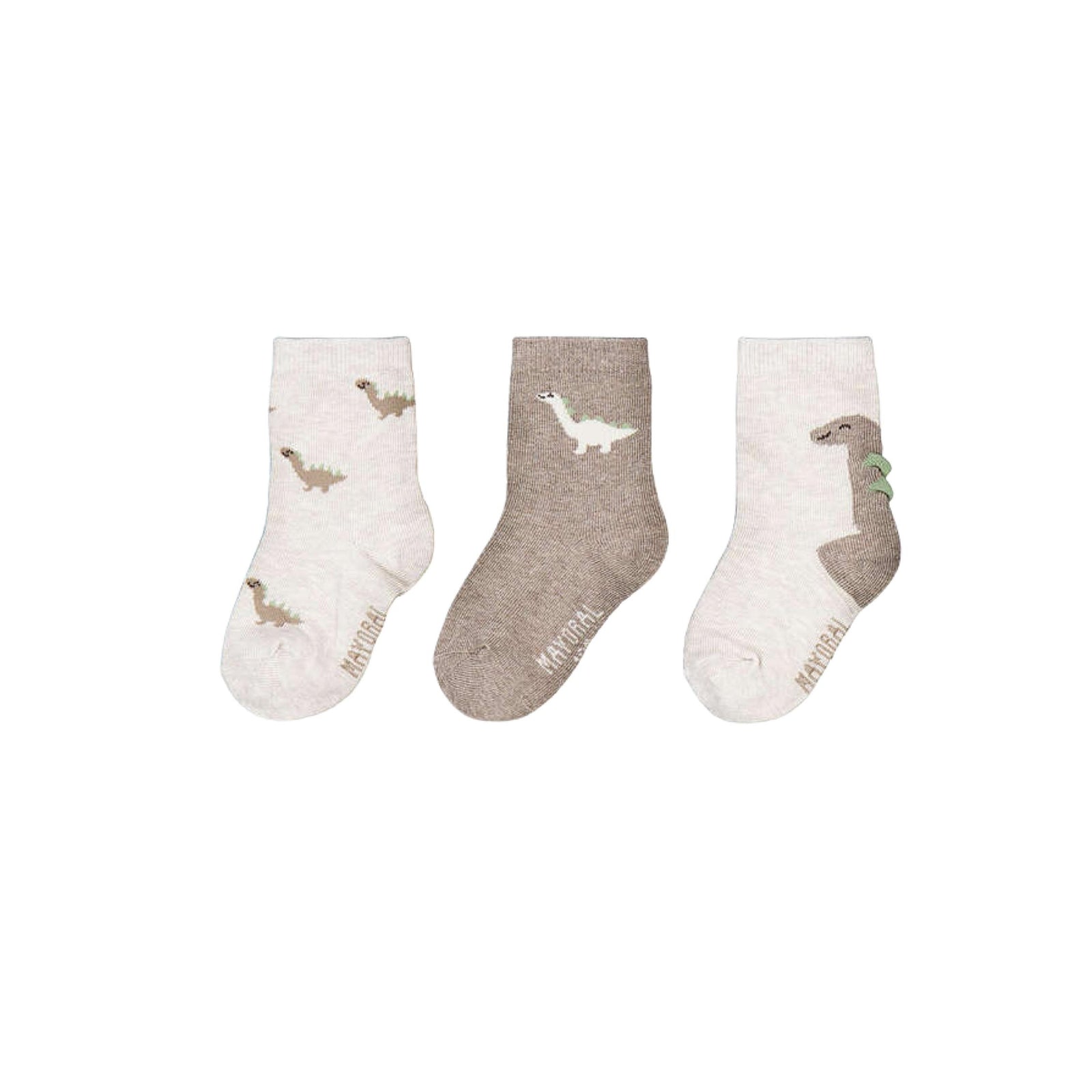 Three pairs of children's socks in a set of off-white, taupe, and off-white, each featuring a dinosaur illustration and the word 'NATURAL' printed near the sole.